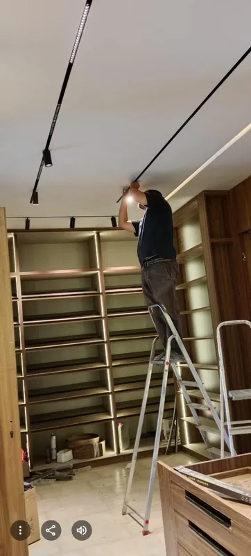 Installation de spots sur rail au plafond d'un magasin